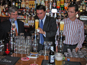 VVD-raadslid Ibo Gülsen demonstreert de werking van de tap van Café Momfer de Mol in de Oude Molstraat voor partijgenoot Charlie Aptroot (links, Tweede Kamer). Uitbater Joep Logjes ziet het wat sceptisch aan, maar is blij met het luisterend oor voor de problemen die de horeca ondervind met de Nederlandse regelgeving.