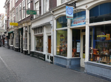 Borstweringen onder de etalagevensters vormen eigenlijk de ‘plinten’ van de straat en geven een prettig straatbeeld. Vaak is er geen borstwering meer aanwezig, maar hier in dit deel van de Schoolstraat is die weer teruggekeerd, dankzij de inzet van een van de winkeliers. Ook de gevelreclame en de borden zijn teruggebracht tot hun essentie.