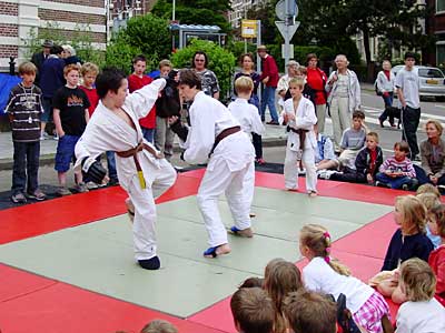 Jonge leerlingen van een sportschool demonstreren gevechtstechnieken op het Bankaplein.