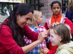 De kinderen laten zich graag schminken door buurtbewoonster Veronica Elizondro.