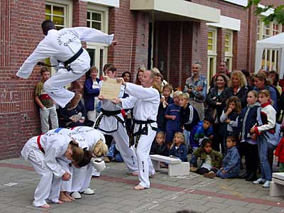 Ivory Winter van Teakwon-do School ‘Charyot’ uit de Aucubastraat trapt na een welgemikte sprong over twee teamgenoten vakkundig een plank in tweëen.